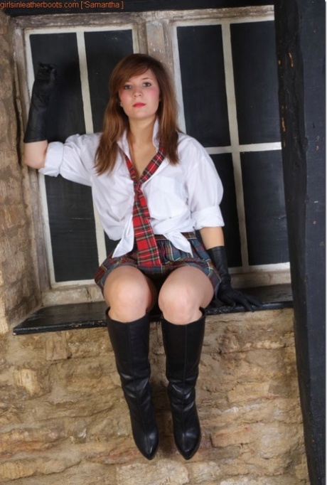 Redheaded girl exposes her breasts in leather gloves and boots
