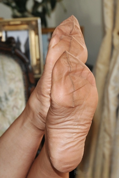 Nylon Sue, une femme d'âge mûr, se débarrasse d'une robe rétro pour montrer ses pieds sexy en bas.