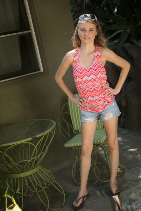 Klein tienermeisje Hannah Hays bevredigt haar kale poesje op een patio stoel