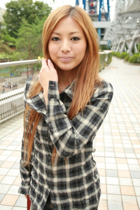 A ruiva japonesa Anna Morisaki chupa uma bebida enquanto está vestida com uma mini-saia