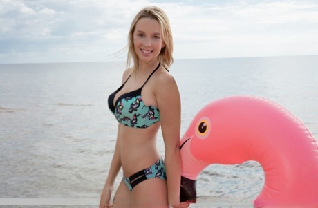 Giovane bionda con grandi gambe si toglie il bikini per posare nuda su un gonfiabile