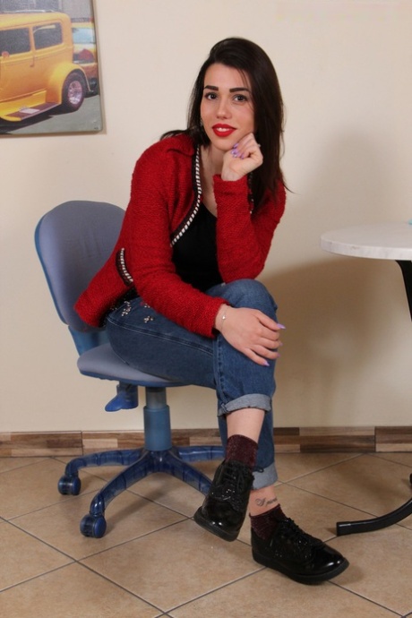 Oblečená brunetka Petra osvobozuje své krásné nohy od lesklých bot a ponožek