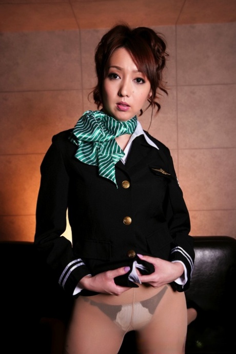 Hermosa chica japonesa suelta los pechos de su uniforme de piloto