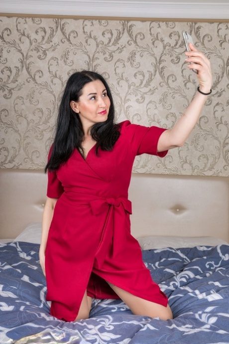 Liliya, una donna di oltre 30 anni, si scatta dei selfie con un vestito rosso prima di spogliarsi