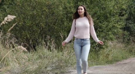 小道でコンクリートブロックの後ろにしゃがみこむ着衣の少女サーシャ。