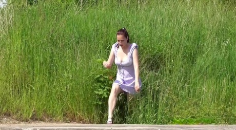 独自一人的女孩Antonia Sainz穿着凉鞋在水泥垫上蹲着小便