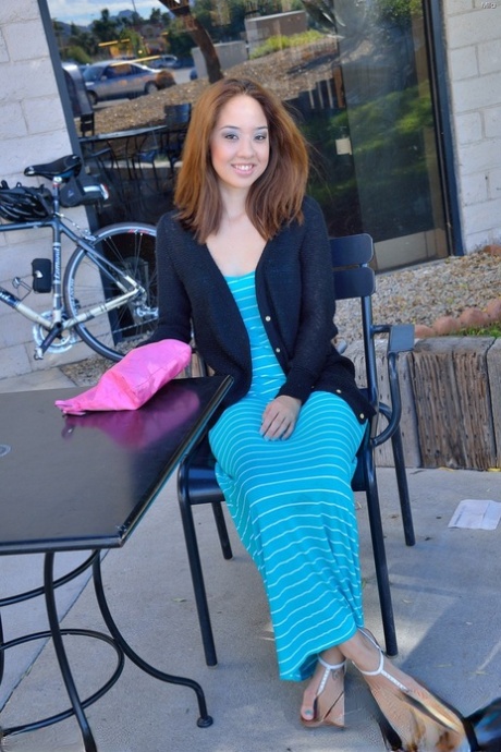 Une rousse coquine dénude ses petits tétons et soulève sa robe longue en public