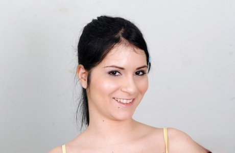 Prachtige tienerbrunette die haar ondergoed uittrekt en haar geschoren vagina laat zien