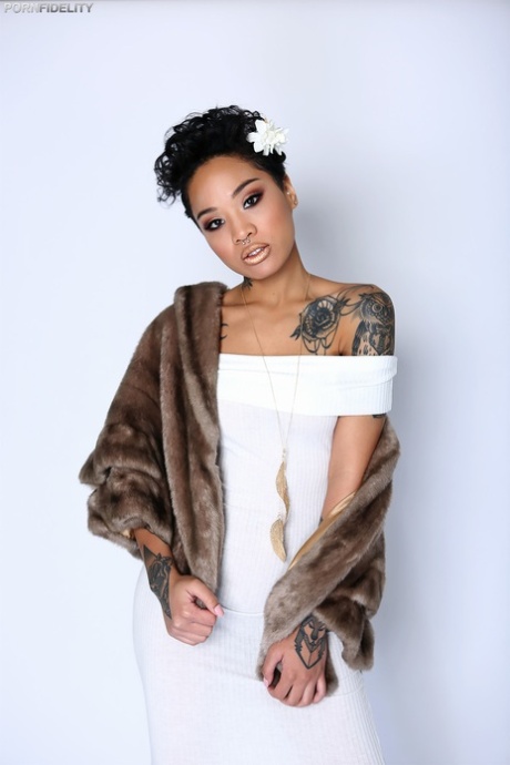 Elegant sort chick honning guld flaunting hendes lækre tatoveringer og naturlige bryster