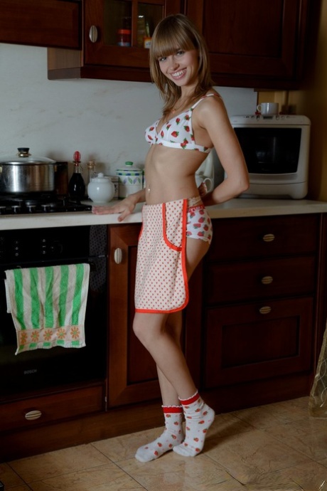 Slim teen with a big mouth Aina plays with a big rubber dildo in the kitchen