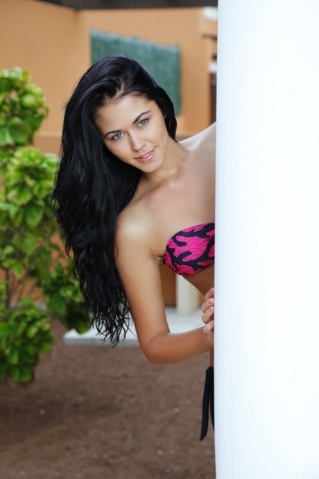 Bela adolescente com um corpo esguio Macy B doffs seu biquíni e poses na piscina