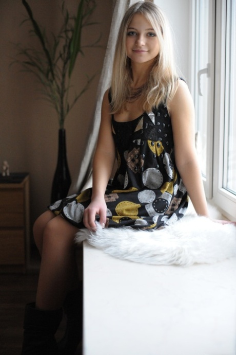 Gullhåret babe Nata E tar av seg støvlene og poserer i kjole og strømper
