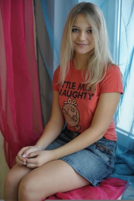 Doce loira teen Natja fica nua por uma janela de uma forma casual