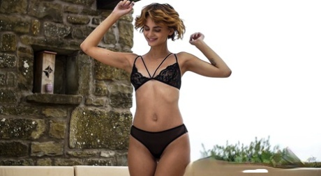 Glamour babe Ariel um doffs sua lingerie preta para nu relaxamento ao ar livre