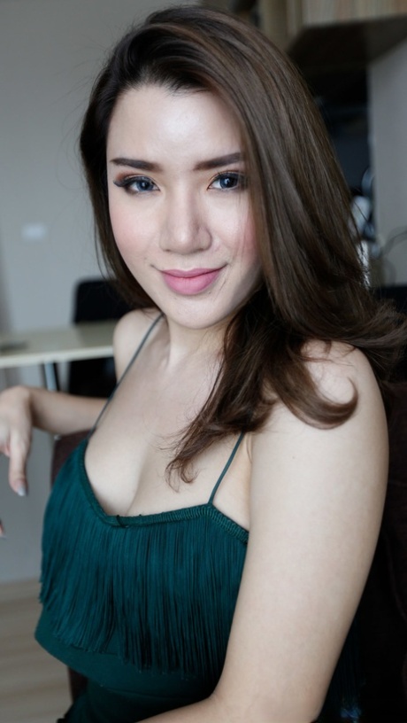 La sexy ladyboy Peach pose en solo dans sa tenue sexy et ses talons hauts.
