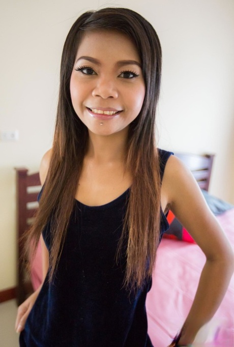 Thai Babe Min zieht sich aus und zeigt ihre schlanke Figur auf dem Bett