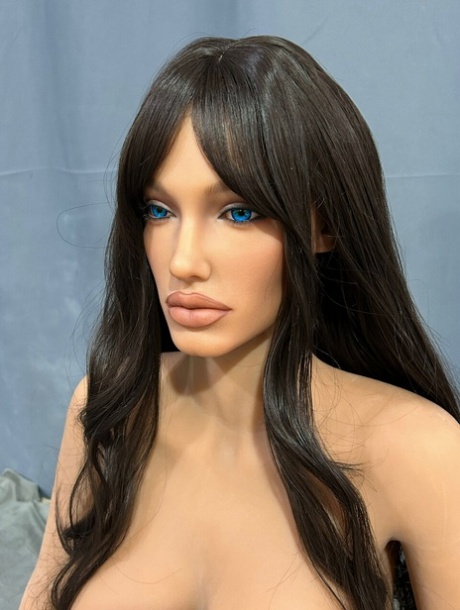 Dark-haired silicone sex doll exposes her hot feet and boobs in a solo